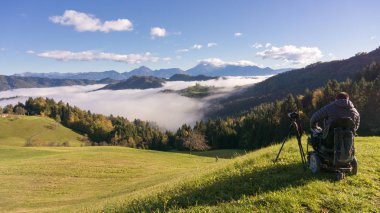 adam tekerlekli sandalye Sisli sabah güzel manzara fotoğrafını çekmek St. Thomas Slovenya