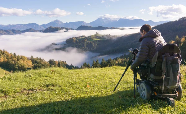 Hombre en silla de ruedas tomando fotos de hermoso paisaje en una mañana brumosa, Santo Tomás Eslovenia —  Fotos de Stock