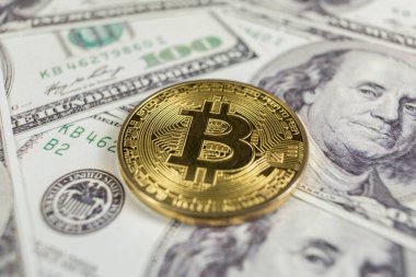 Altın Bitcoin yüz dolar faturaları üzerinde. Yakın çekim, makro çekim.