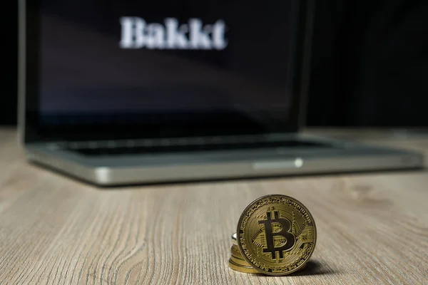 Nahaufnahme einer Bitcoin-Münze mit dem Bakkt-Logo auf einem Laptop-Bildschirm hinter der Münze — Stockbild Bitcoin-Münze mit dem Bakkt-Logo auf einem Laptop-Bildschirm, Slowenien - 23. Dezember 2018 — Stockfoto