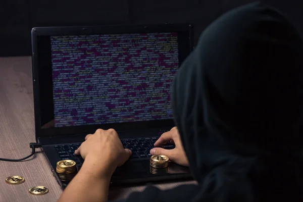 有其头套的黑客用笔记本电脑偷比特币 — 图库照片