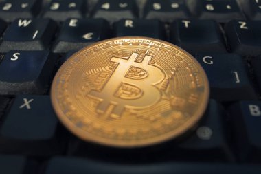 Bir siyah bilgisayar klavyesinde yalan altın Bitcoin madeni para. Dijital para kavramı.