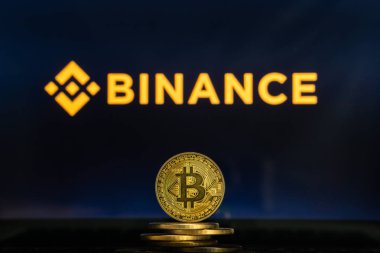Binance logo Bitcoin cryptocurency para yığını ile bilgisayar ekranında.
