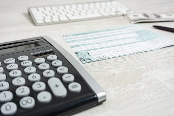 Nas podatek formularza obok komputera klawiatura, kalkulator i podatek formularza 1040. podatek tworzą nam dochód office ręcznie wypełnienia koncepcji — Zdjęcie stockowe