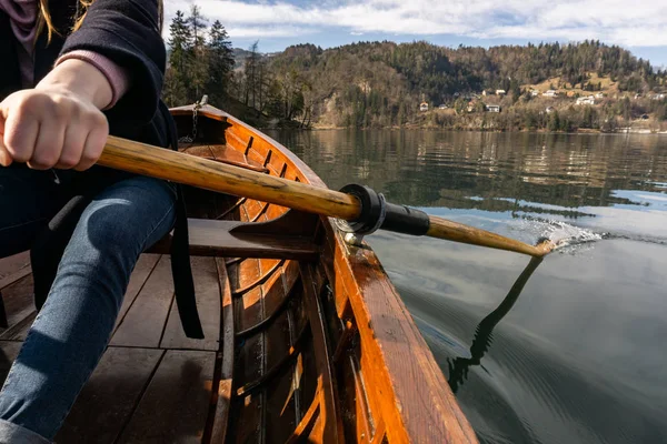 Fiatal nő segítségével a lapát egy fából készült hajón - tó Bled Szlovénia evezés, fából készült csónakok — Stock Fotó