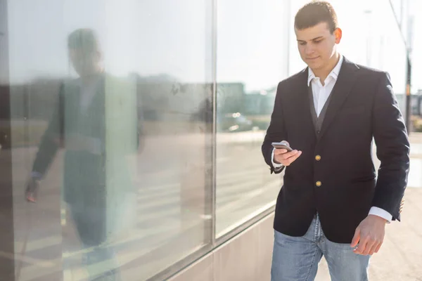 Walking affärsman med Smartphone utsidan — Stockfoto