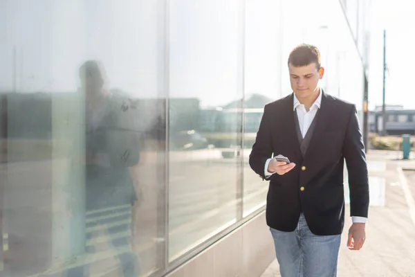 Walking affärsman med Smartphone utsidan — Stockfoto