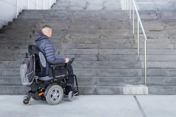 Hombre en silla de ruedas mirando escaleras — Foto de Stock