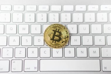 Cyptocurrency altın Bitcoin arka planda beyaz klavye üzerine döşenmesi. elektronik sanal para sembolü.