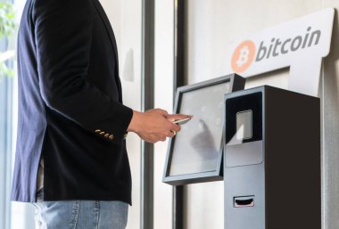 İşadamı satın alma ve aktarma cryptocurrency doğru hareket eden telefon--dan alış ve satış cryptocurrency için Atm makine.