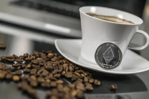 Moneda criptomoneda Ethereum con taza de café y granos de café — Foto de Stock