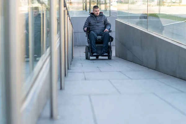 Homme en fauteuil roulant électrique utilisant une rampe — Photo