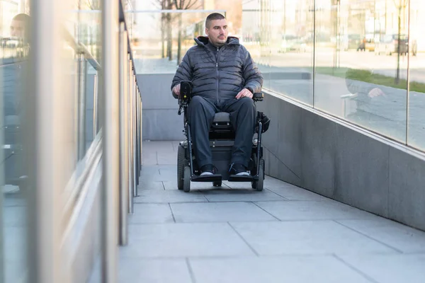 Uomo su una sedia a rotelle elettrica che utilizza una rampa — Foto Stock
