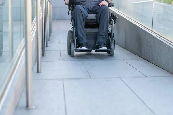 Człowiek w elektrycznym wózku inwalidzkim przy użyciu rampy — Zdjęcie stockowe