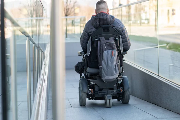 Człowiek w elektrycznym wózku inwalidzkim przy użyciu rampy — Zdjęcie stockowe