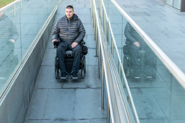 Людина в електричному інвалідному візку з використанням пандуса — стокове фото