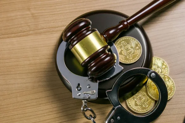 Gavel i kajdanki z bitcoinami na drewnianym biurku. Koncepcja prawna kryptowaluta. — Zdjęcie stockowe