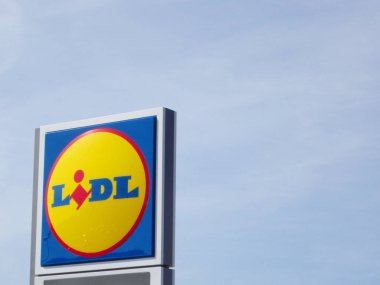 Bir süpermarkette mavi gökyüzüne karşı Lidl logosu