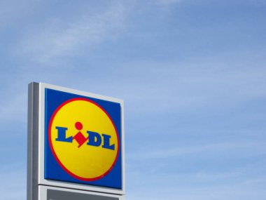 Bir süpermarkette mavi gökyüzüne karşı Lidl logosu