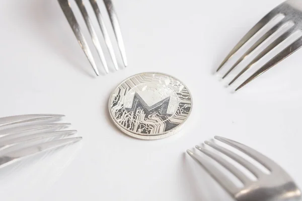 Monero cryptocurrenie Coin geplaatst tussen vorken met reflectie, harde vork — Stockfoto