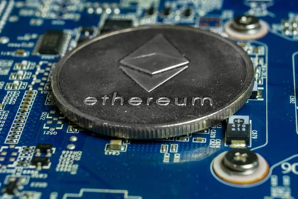 A single Ethereum coin on the blue computer motherboard — Stock Photo, Image
