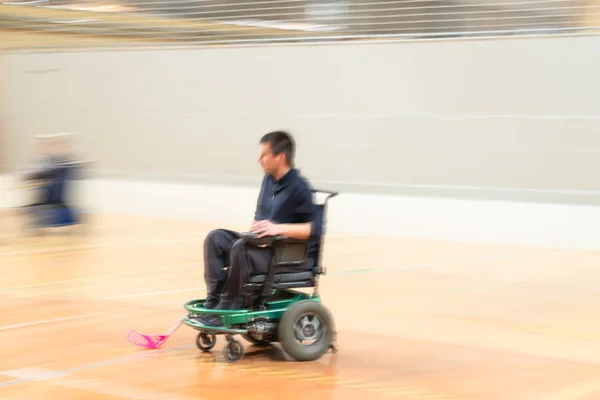Homme handicapé en mouvement sur un fauteuil roulant électrique faisant du sport, du hockey en fauteuil roulant. IWAS - Fédération internationale de sport en fauteuil roulant et amputé — Photo