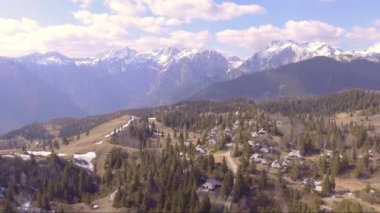 Geri çek incik dolu güzel Velika planina, küçük evler ve dağlar geri. Hava kamerası çekimi. Manzara panorama güneşli bir gün. Slovenya