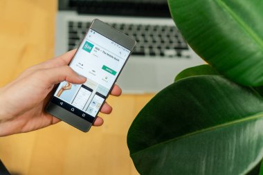 Ljubljana, Slovenya 29.4.2019: Iş adamı tutarak akıllı telefon ve N26 bankalar uygulamasını indirmek için çalışıyor