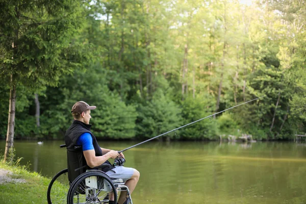 Behinderter beim Rollstuhlfischen am See — Stockfoto