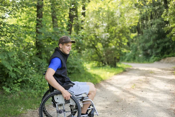 Hombre discapacitado en silla de ruedas en la naturaleza —  Fotos de Stock