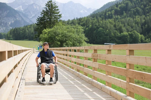 Behinderter junger Mann im Rollstuhl — Stockfoto