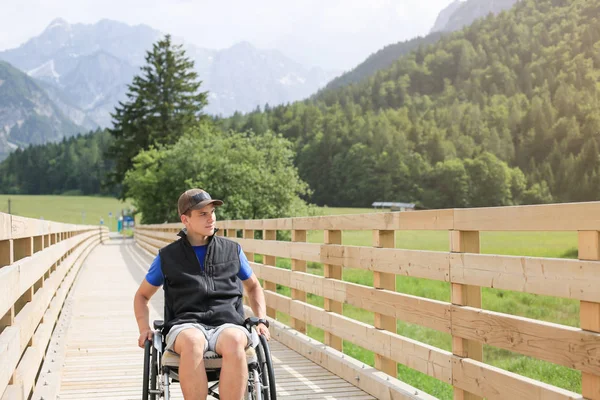 Behinderter junger Mann im Rollstuhl — Stockfoto