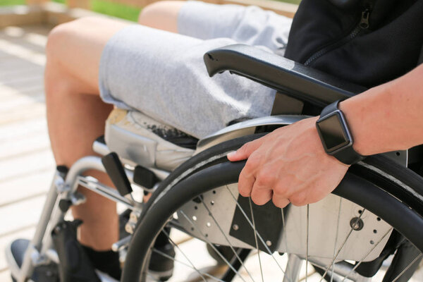 Инвалидный молодой человек в инвалидном кресле
