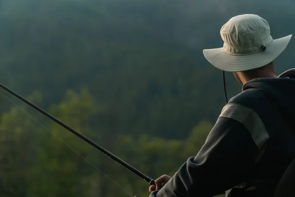 Joven en silla de ruedas pescando en el hermoso lago al atardecer, amanecer —  Fotos de Stock