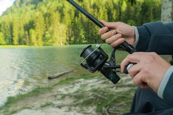 Closeup of Fisherman s hand with spinning - summer fishing season. — Stock Photo, Image