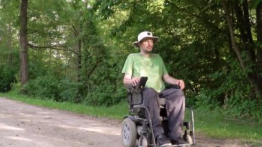 Tekerlekli sandalyedeki engelli gencin etrafındaki doğayı gözlemlemesini yavaş hareket le takip etmek