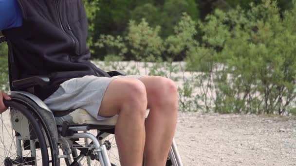 Медленное приближение инвалида молодого студента в инвалидном кресле, проходящего мимо — стоковое видео