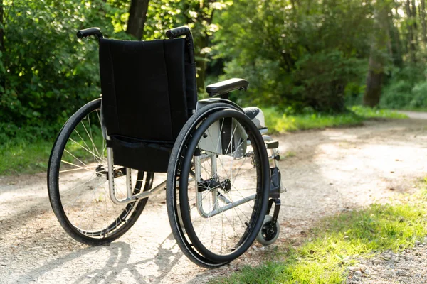 Empty wheelchair parked in park, health care concept — Stock Photo, Image