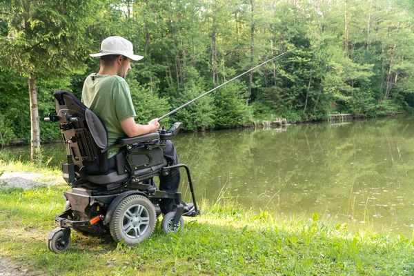 晴れた日にナテの美しい池で電動車椅子釣りで幸せな男 — ストック写真