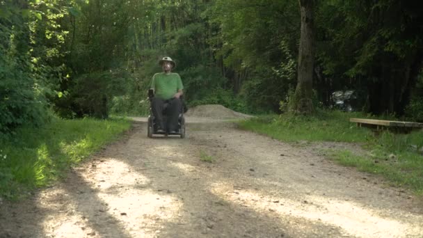 4k résolution portrait vidéo d'un homme handicapé dans un fauteuil roulant électrique dans la nature — Video