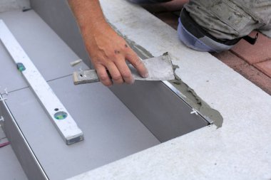 Kiremitçi eller yerde Seramik Karo döşeme.