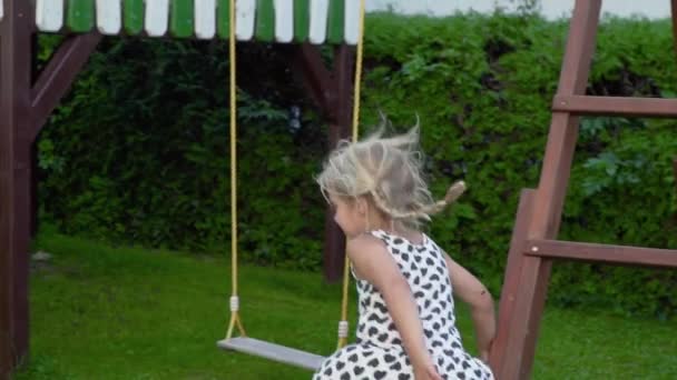 Уповільнення 3-5 років маленька блондинка грає і розважається на відкритому повітрі в сонячному саду, насолоджуючись дитинством — стокове відео