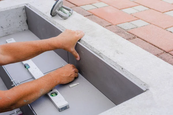 The hands of the tiler are laying the ceramic tile on the floor. — Stock Photo, Image