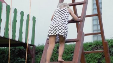 3-5 yaşındaki küçük sarışın kız oynarken ve güneşli arka bahçe bahçede çocukluk zevk açık havada eğlenmek Slowmotion