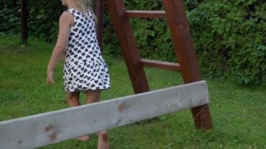 3-5 yaşındaki küçük sarışın kız oynarken ve güneşli arka bahçe bahçede çocukluk zevk açık havada eğlenmek Slowmotion