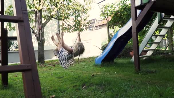 3-5 yaşındaki küçük sarışın kız oynarken ve güneşli arka bahçe bahçede çocukluk zevk açık havada eğlenmek Slowmotion — Stok video