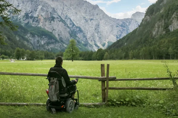 Hombre en silla de ruedas en un bosque . — Foto de Stock