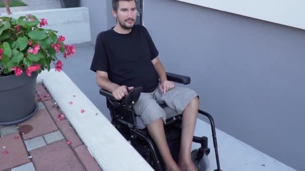 Vidéo ralentie d'un homme en fauteuil roulant électrique utilisant une rampe d'accès à une maison accessible — Video