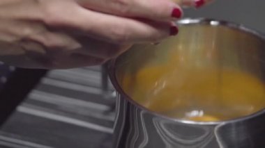 Dişi eller kasede yumurta kırıyor. Mutfakta yumurta kırmak. Yavaş çekim.
