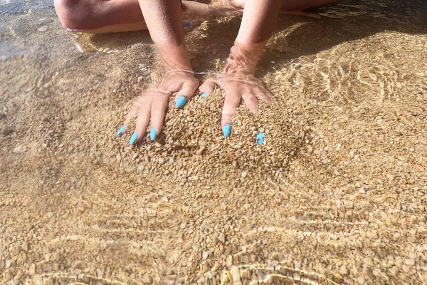 Girl holding a sand sea background. concept of vacation in warmer climes, the trip to the sea